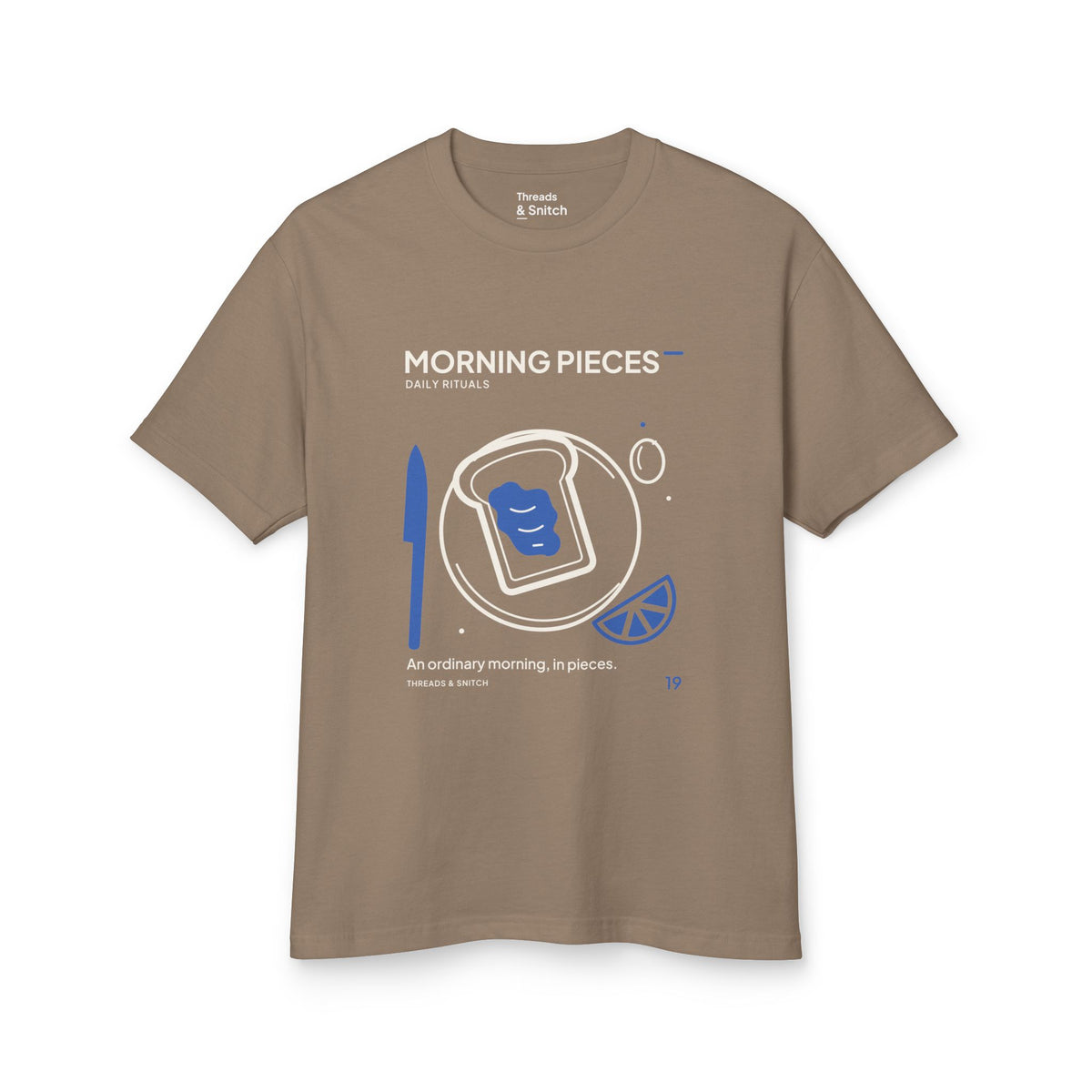 Mockup of Morning Pieces Breakfast Tee in Faded Brown, front view showing toast on a plate beside a citrus slice and blue knife.