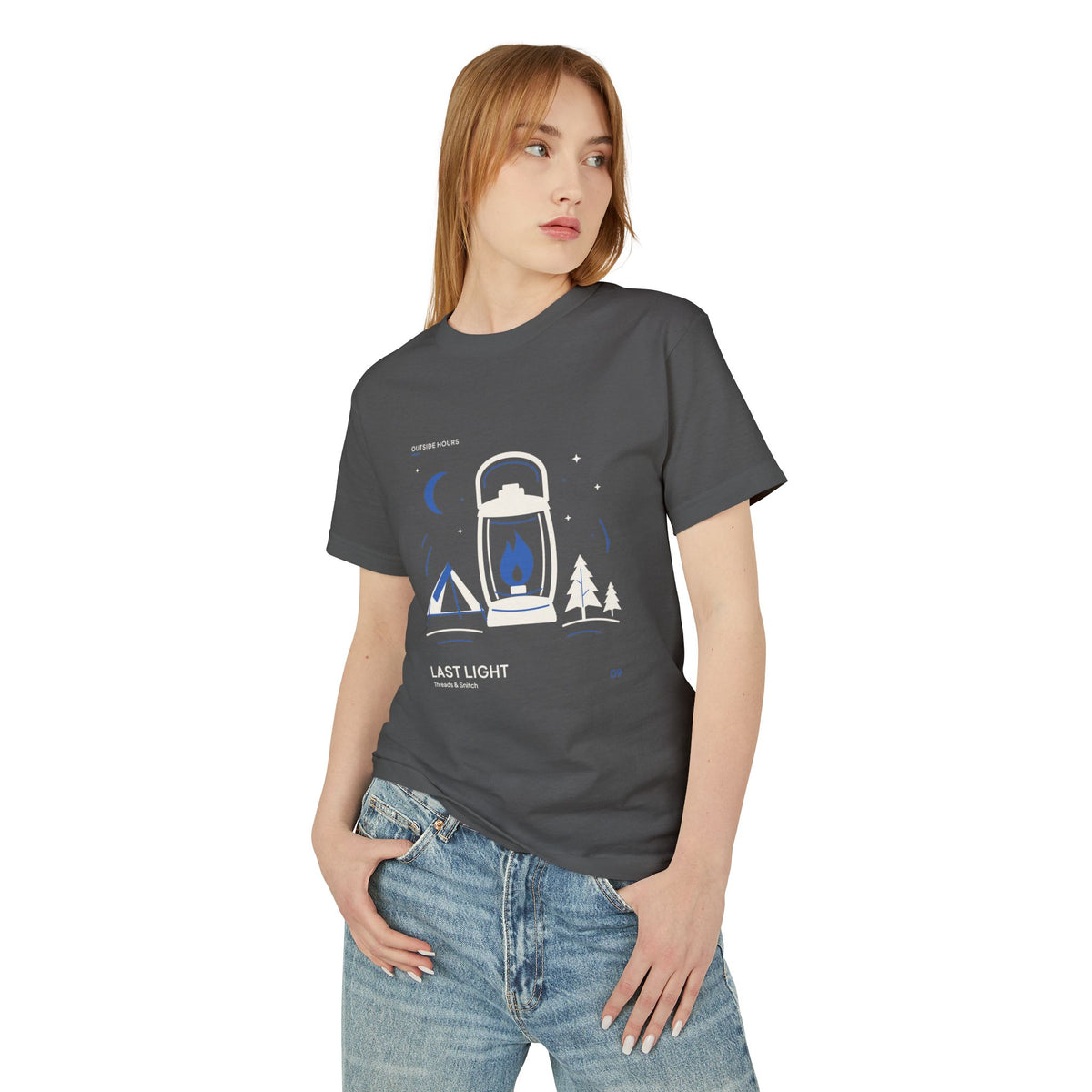 Model mockup of Last Light Lantern Graphic Tee in Faded Black, front view showing lantern, tent, trees and blue crescent moon.