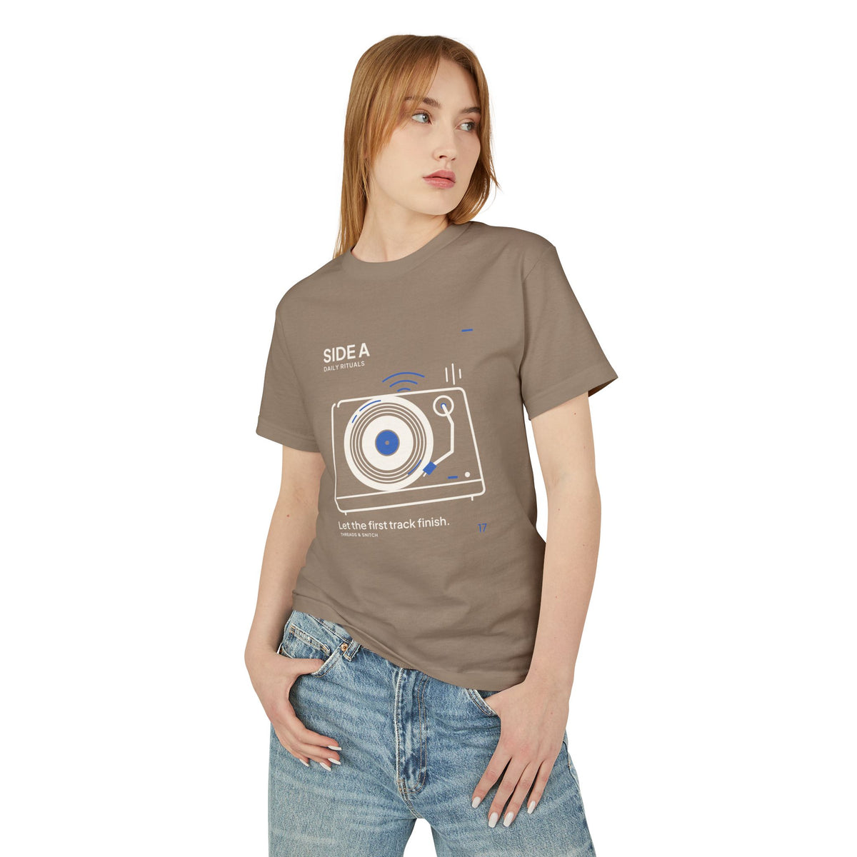 Model mockup of Side A Record Player Tee in Faded Brown, front view showing record player with open circular grooves, tonearm and blue sound marks.