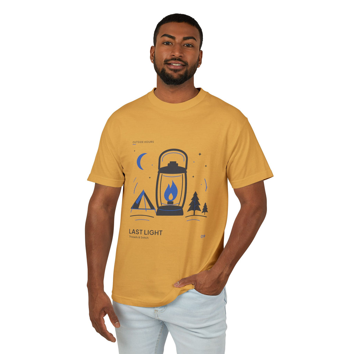 Model mockup of Last Light Lantern Graphic Tee in Faded Mustard, front view showing lantern, tent, trees and blue crescent moon.