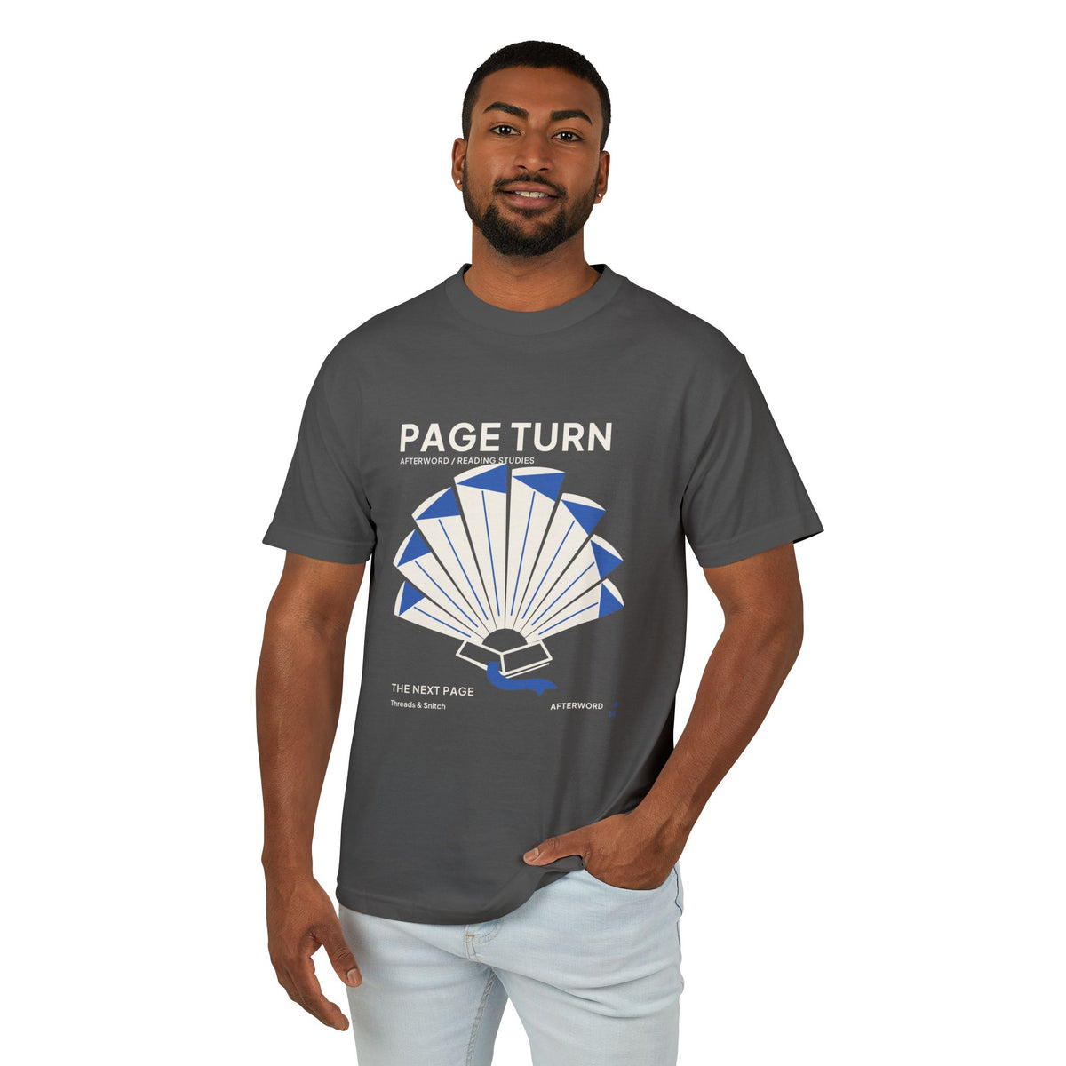 Model mockup of Page Turn Book Graphic Tee in Faded Black, front view showing book pages fanned into a radial shape with blue folds and bookmark.