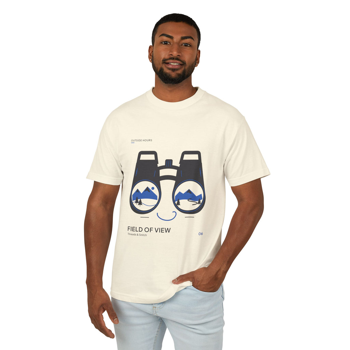 Model mockup of Field of View Binoculars Tee in Faded Cream, front view showing binoculars with mountain and river landscapes inside the lenses.