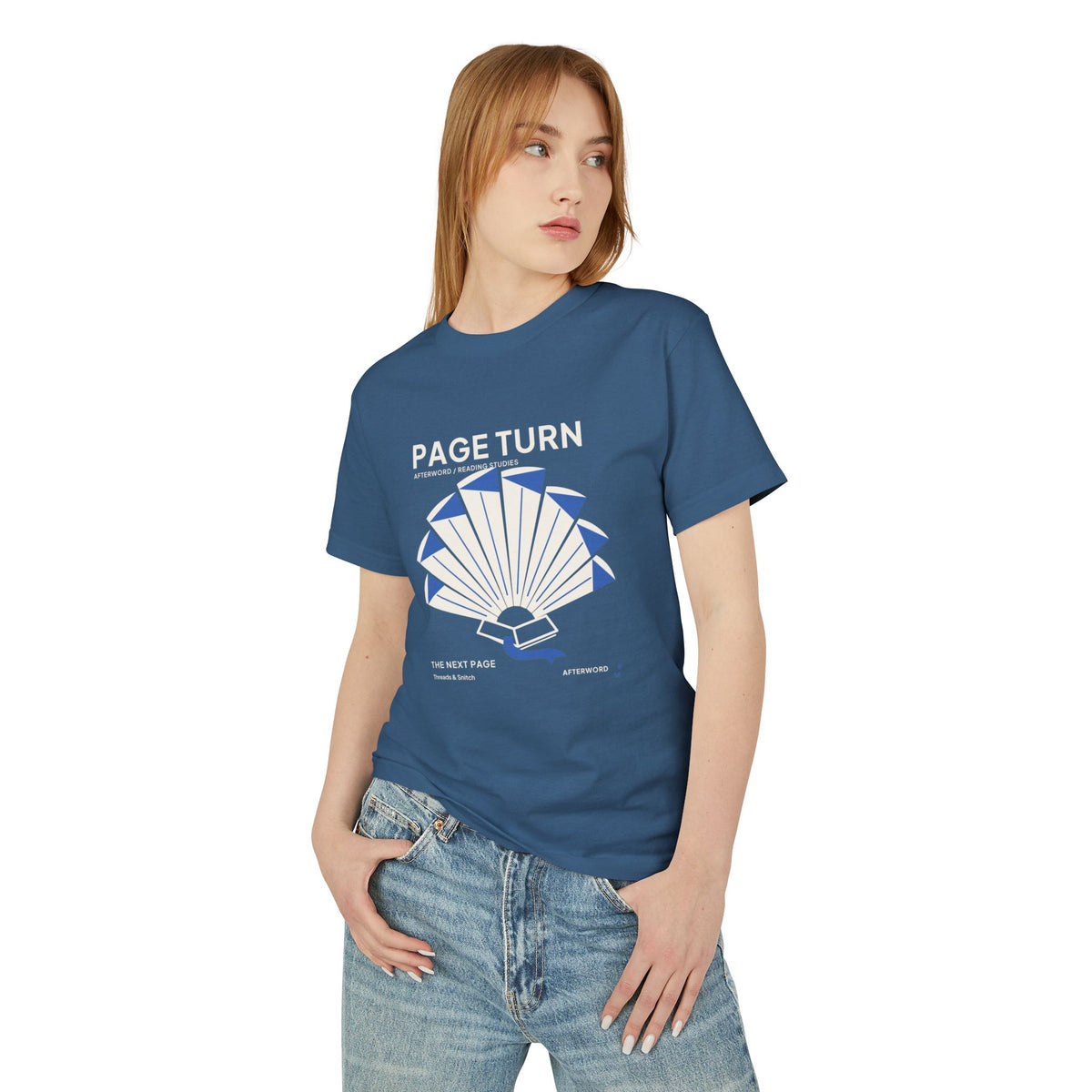 Model mockup of Page Turn Book Graphic Tee in Faded Navy, front view showing book pages fanned into a radial shape with blue folds and bookmark.