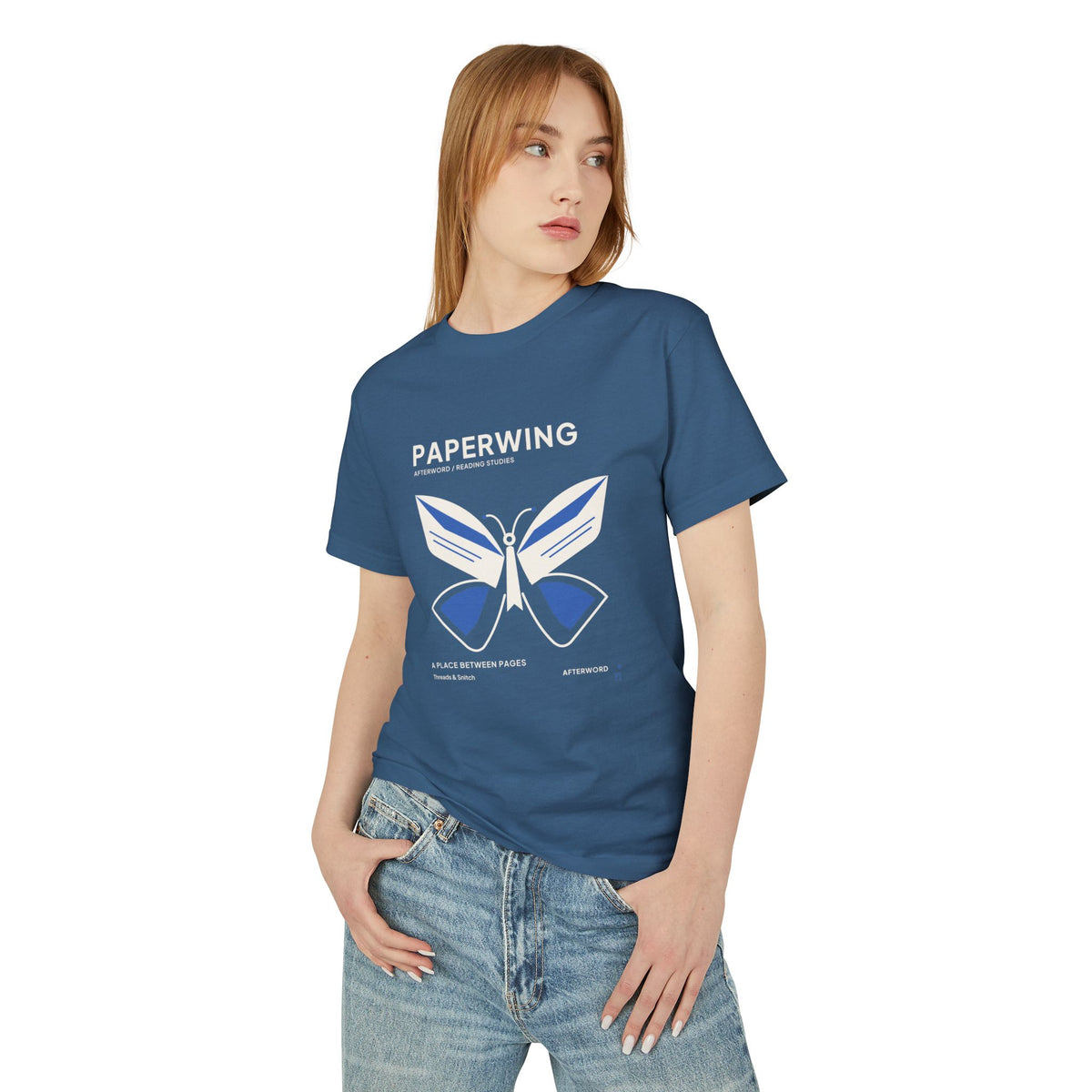 Model mockup of Paperwing Bookish Moth Tee in Faded Navy, front view showing moth formed from folded-paper wings and a bookmark-like body.