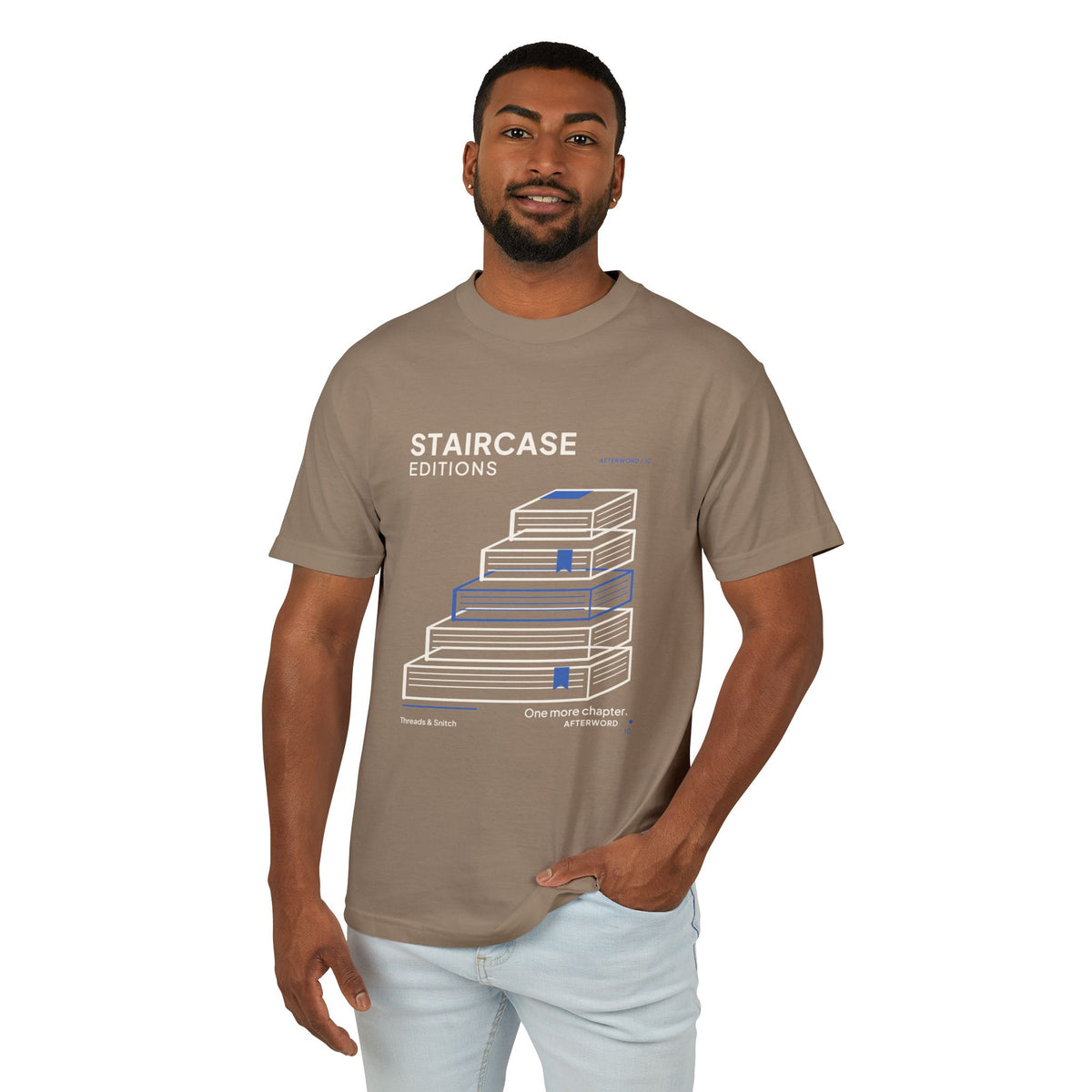 Model mockup of Staircase Editions Book Stack Tee in Faded Brown, front view showing five staggered books forming stairs with blue bookmarks.