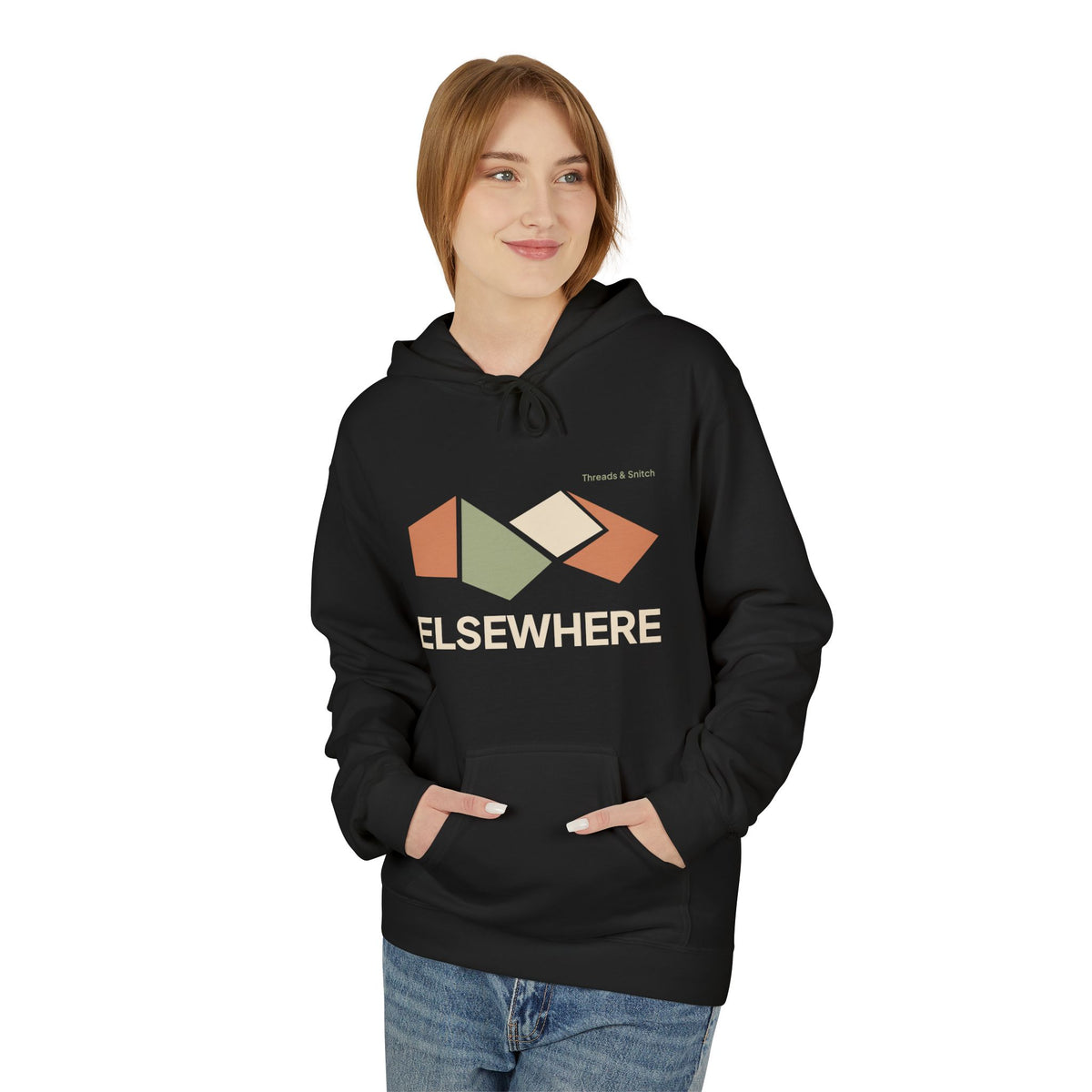 Model mockup of Elsewhere Folded Form Graphic Hoodie in Black, front view showing four folded paper-like panels above Elsewhere lettering.