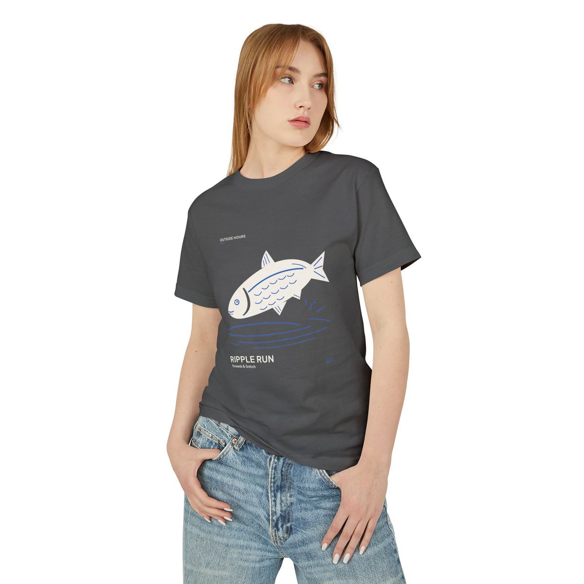 Model mockup of Ripple Run Fish Graphic Tee in Faded Black, front view showing fish above wide blue water ripples.