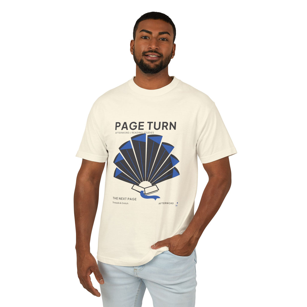 Model mockup of Page Turn Book Graphic Tee in Faded Cream, front view showing book pages fanned into a radial shape with blue folds and bookmark.