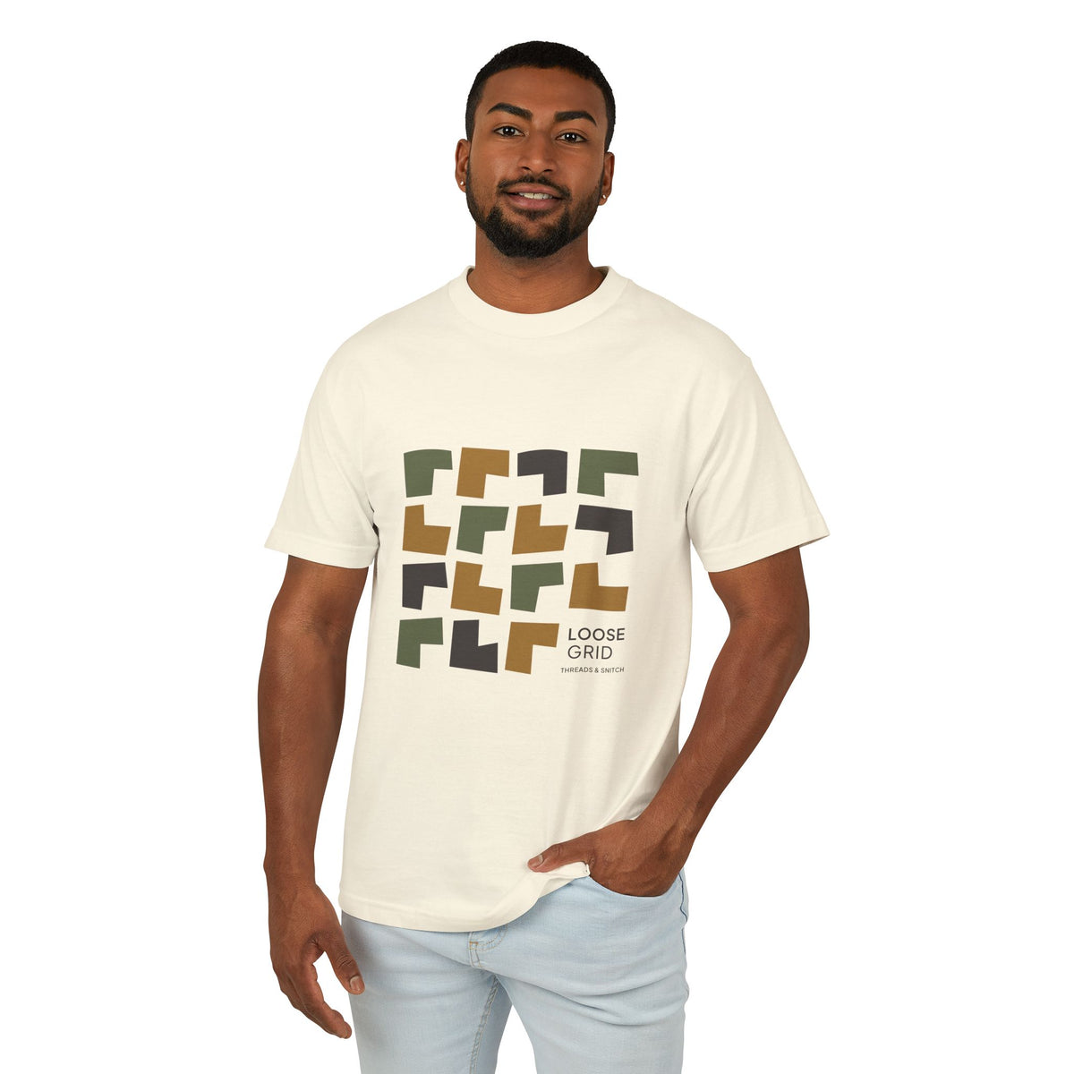 Model mockup of Loose Grid Pattern Graphic Tee in Faded Cream, front view showing an irregular grid of open-cut geometric tiles with Loose Grid lettering.