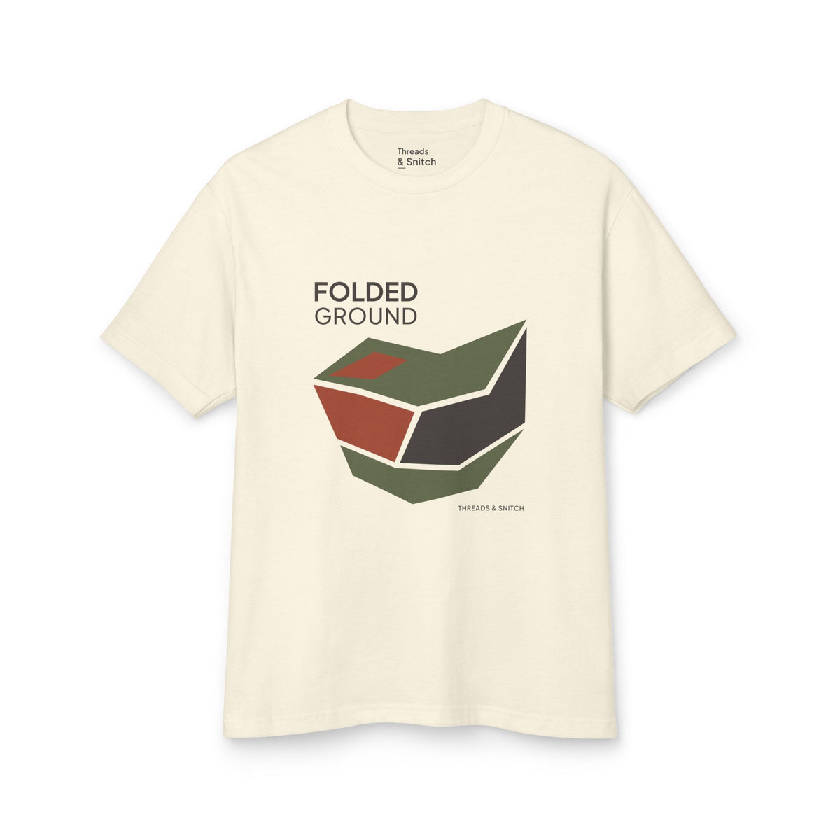 Mockup of Folded Ground Geometric Graphic Tee in Faded Cream, front view showing angular folded planes with open channels and Folded Ground lettering.