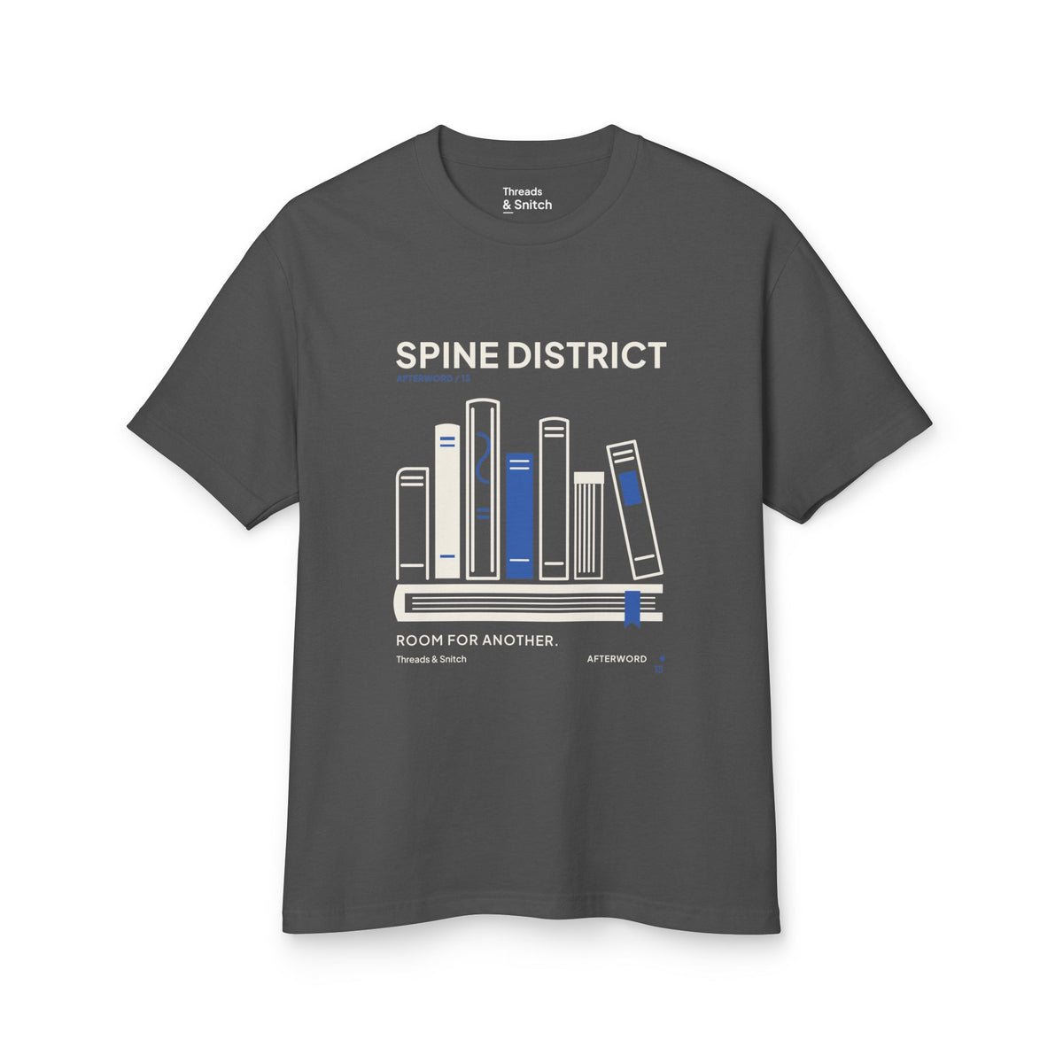 Mockup of Spine District Book Spine Tee in Faded Black, front view showing varied book spines arranged as a skyline above a horizontal book.