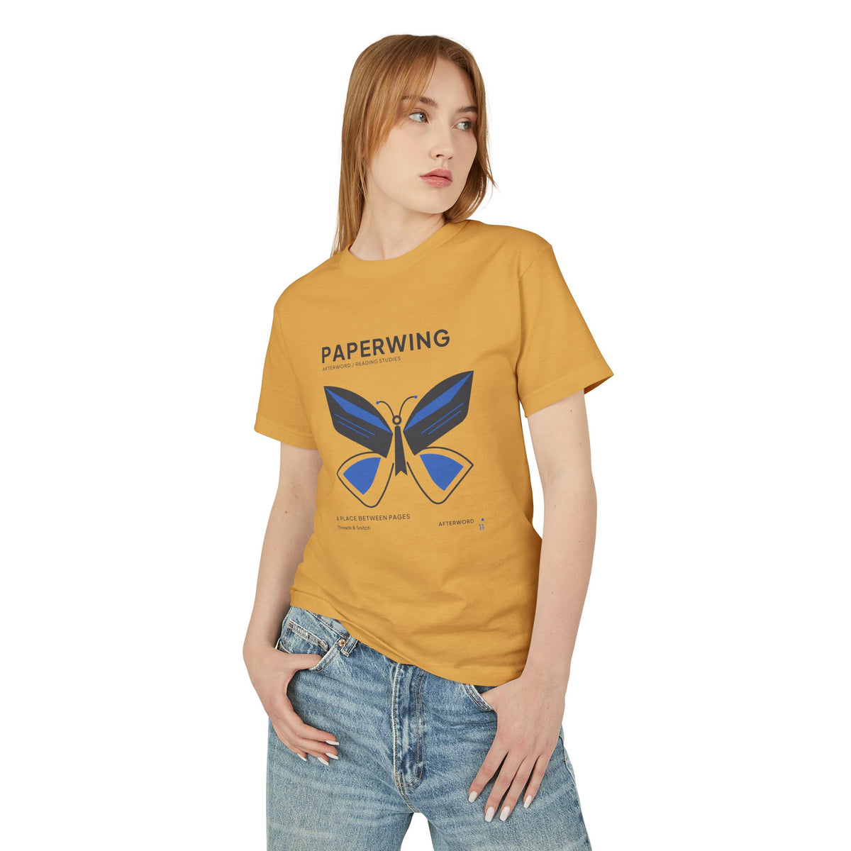 Model mockup of Paperwing Bookish Moth Tee in Faded Mustard, front view showing moth formed from folded-paper wings and a bookmark-like body.
