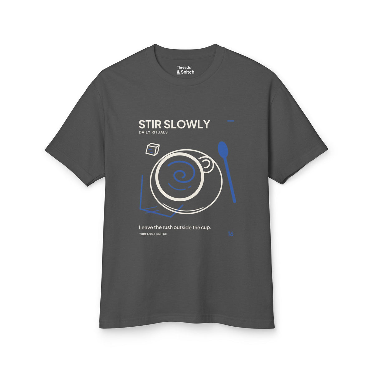 Mockup of Stir Slowly Cup & Spoon Tee in Faded Black, front view showing cup and saucer with blue stirring spiral and oversized spoon.