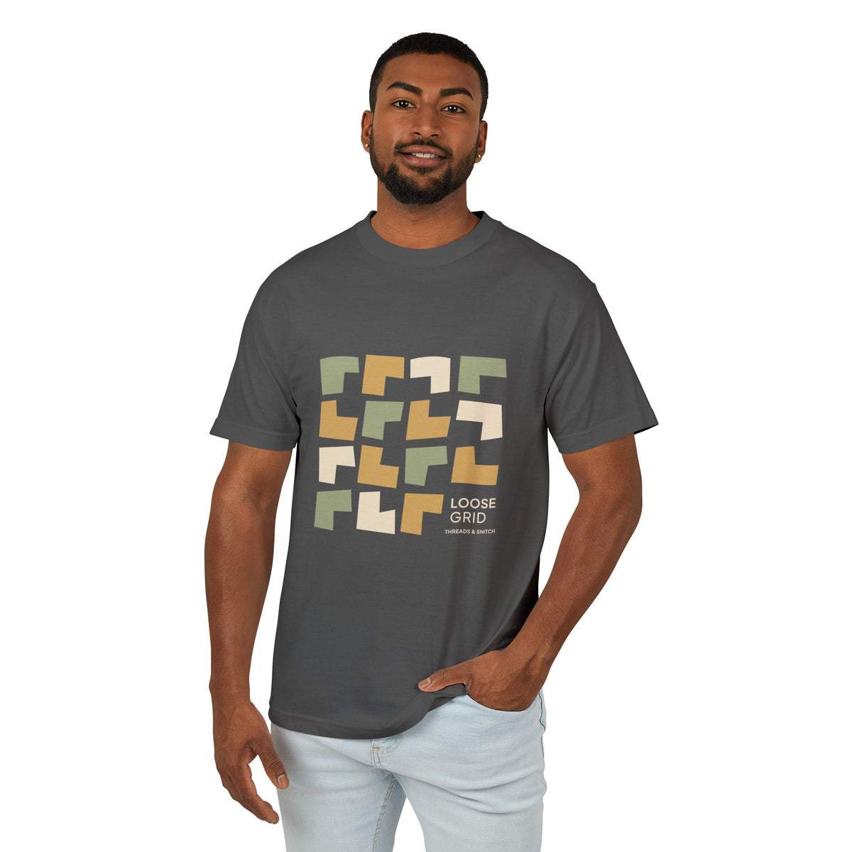 Model mockup of Loose Grid Pattern Graphic Tee in Faded Black, front view showing an irregular grid of open-cut geometric tiles with Loose Grid lettering.