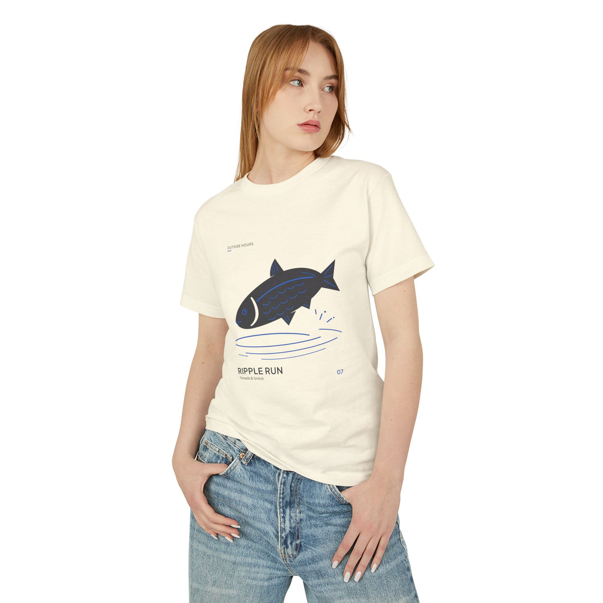 Model mockup of Ripple Run Fish Graphic Tee in Faded Cream, front view showing fish above wide blue water ripples.