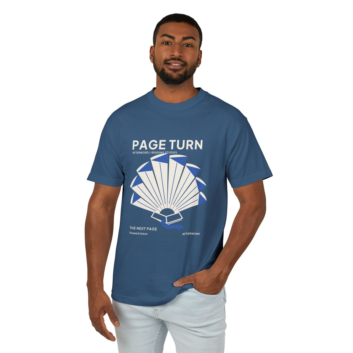 Model mockup of Page Turn Book Graphic Tee in Faded Navy, front view showing book pages fanned into a radial shape with blue folds and bookmark.
