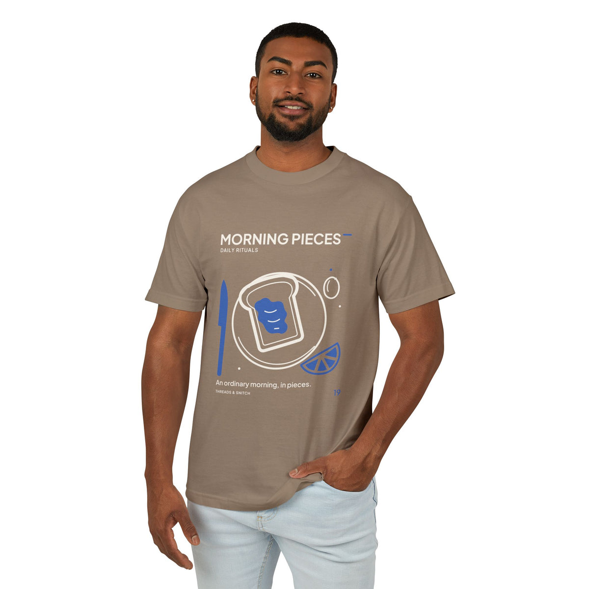 Model mockup of Morning Pieces Breakfast Tee in Faded Brown, front view showing toast on a plate beside a citrus slice and blue knife.