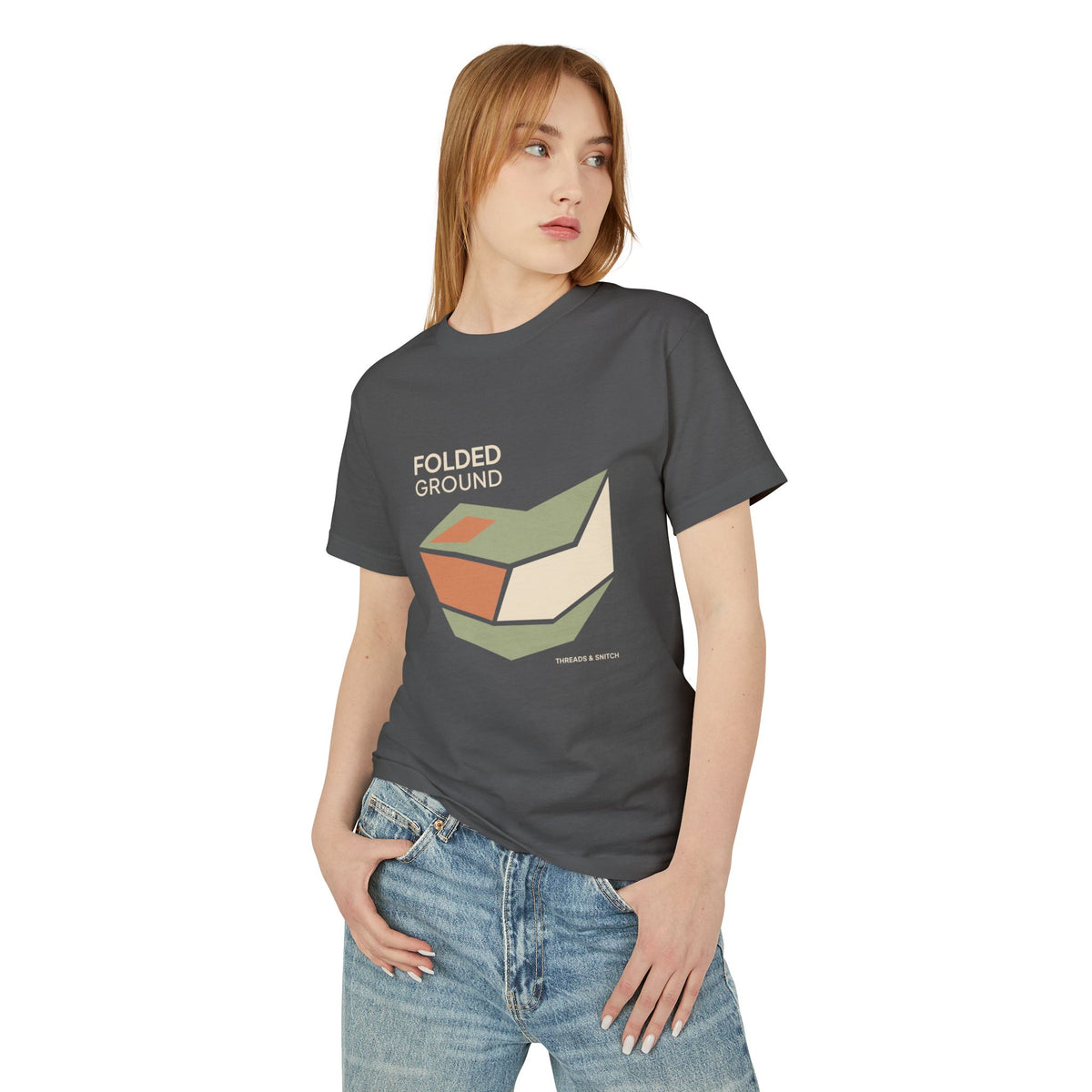 Model mockup of Folded Ground Geometric Graphic Tee in Faded Black, front view showing angular folded planes with open channels and Folded Ground lettering.