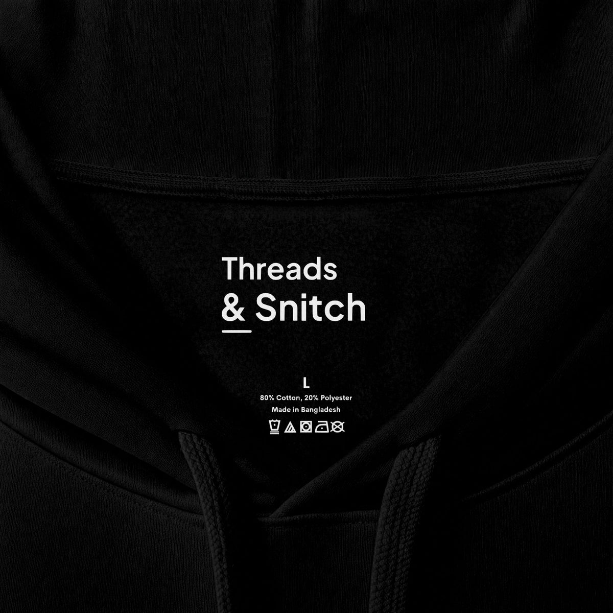 Mockup detail of the printed Threads & Snitch inner-neck label on Held Together Knot Graphic Hoodie in Black.