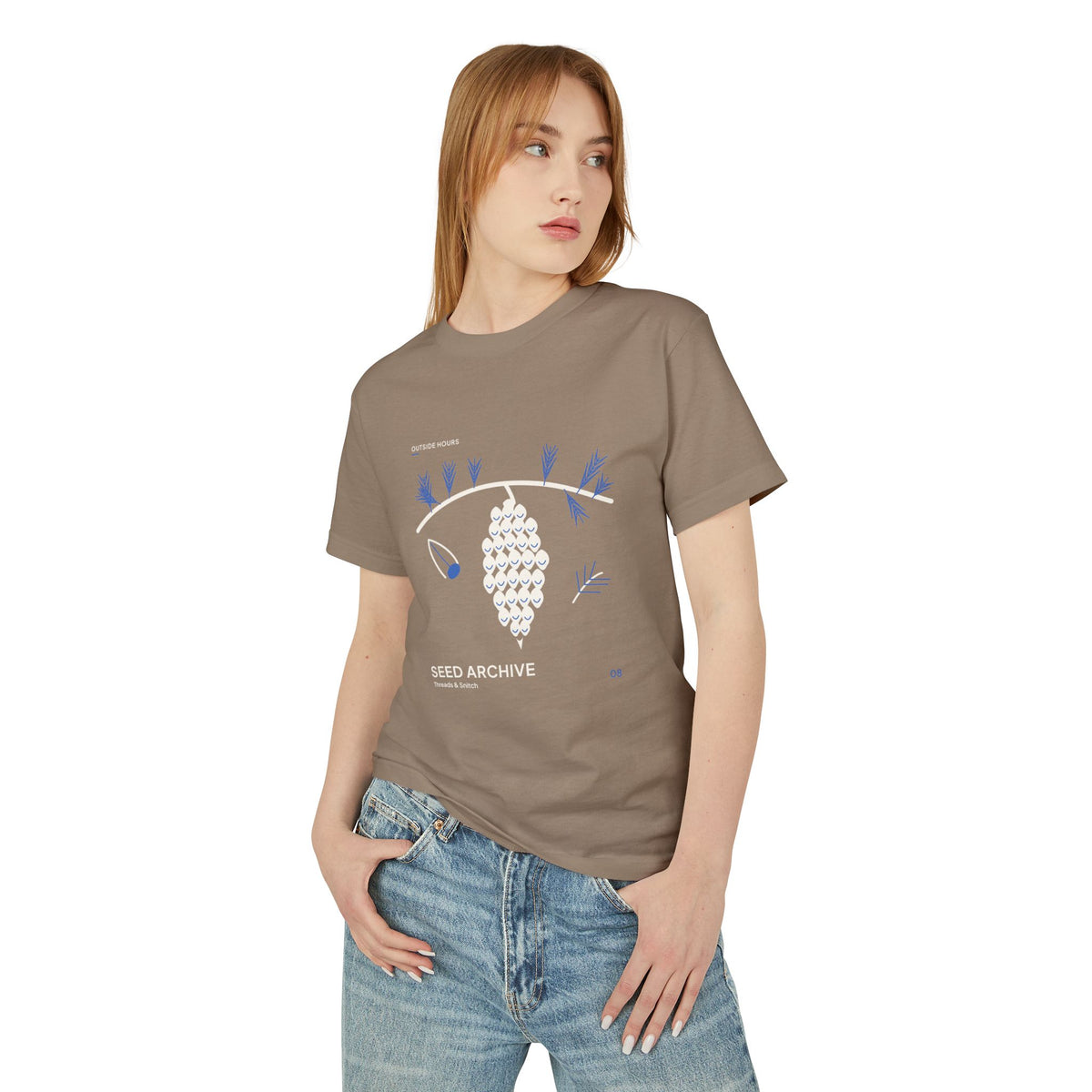 Model mockup of Seed Archive Pinecone Tee in Faded Brown, front view showing pinecone beneath needle sprays with a separate winged seed.