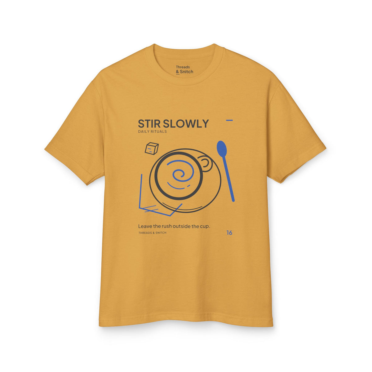 Mockup of Stir Slowly Cup & Spoon Tee in Faded Mustard, front view showing cup and saucer with blue stirring spiral and oversized spoon.