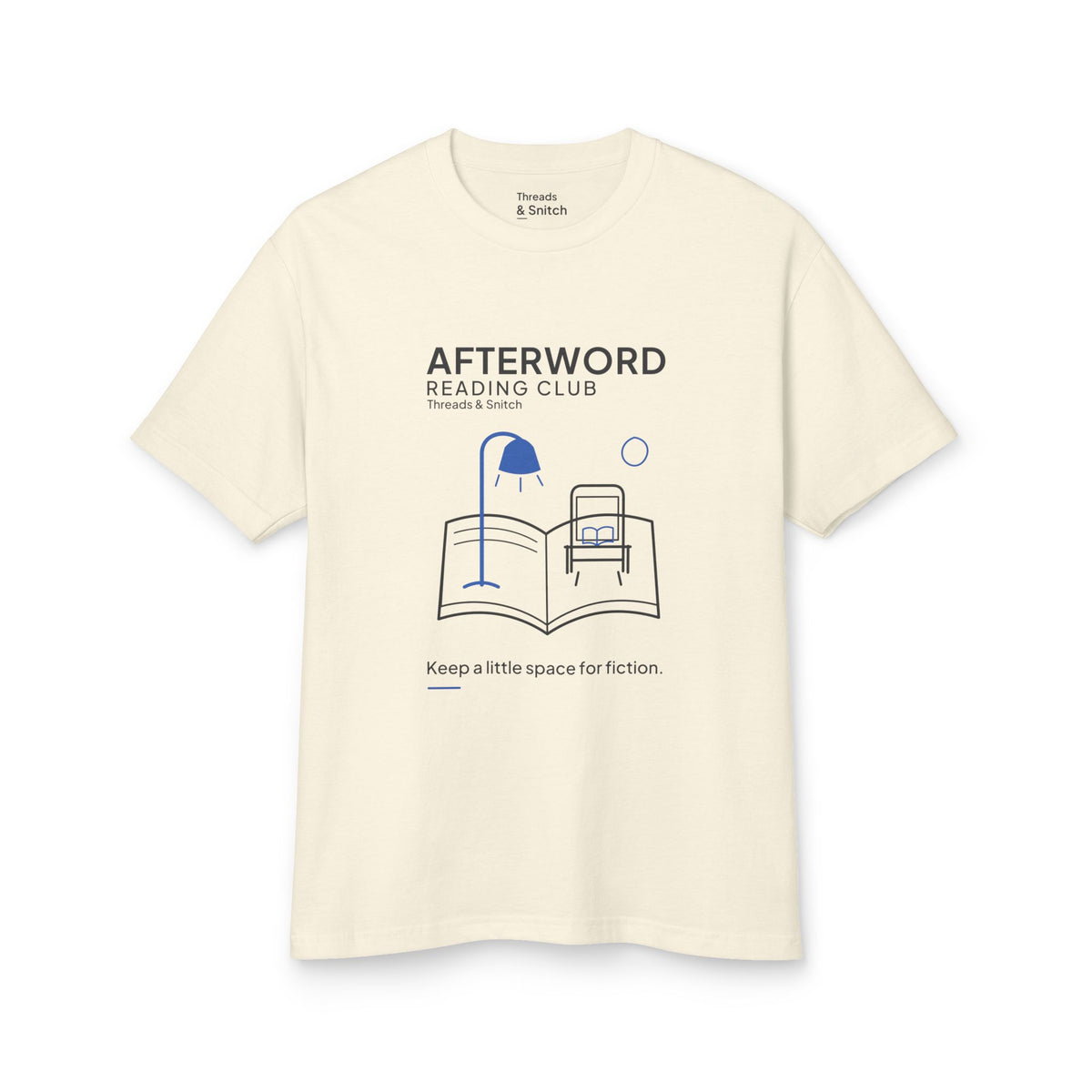 Mockup of Afterword Reading Room Tee in Faded Cream, front view showing open book forming a room with an armchair and blue lamp.