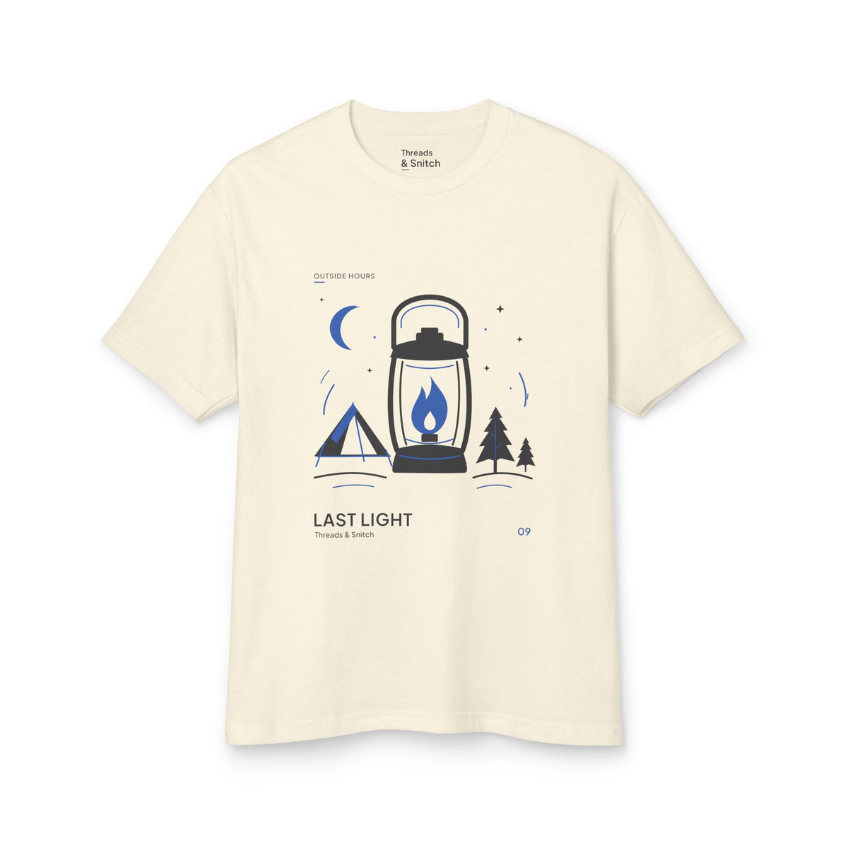 Mockup of Last Light Lantern Graphic Tee in Faded Cream, front view showing lantern, tent, trees and blue crescent moon.