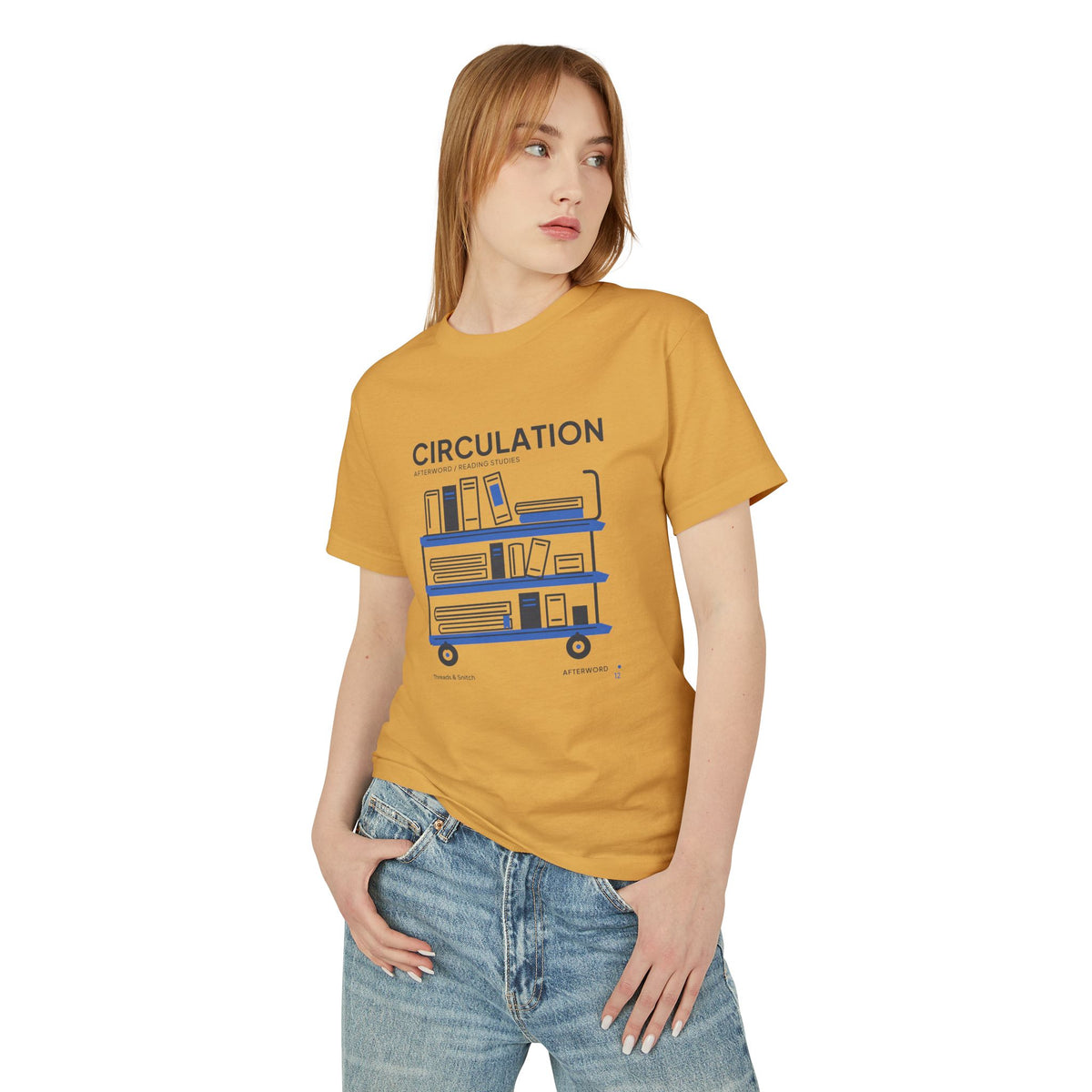Model mockup of Circulation Library Cart Tee in Faded Mustard, front view showing three-tier library cart filled with books and blue shelves.